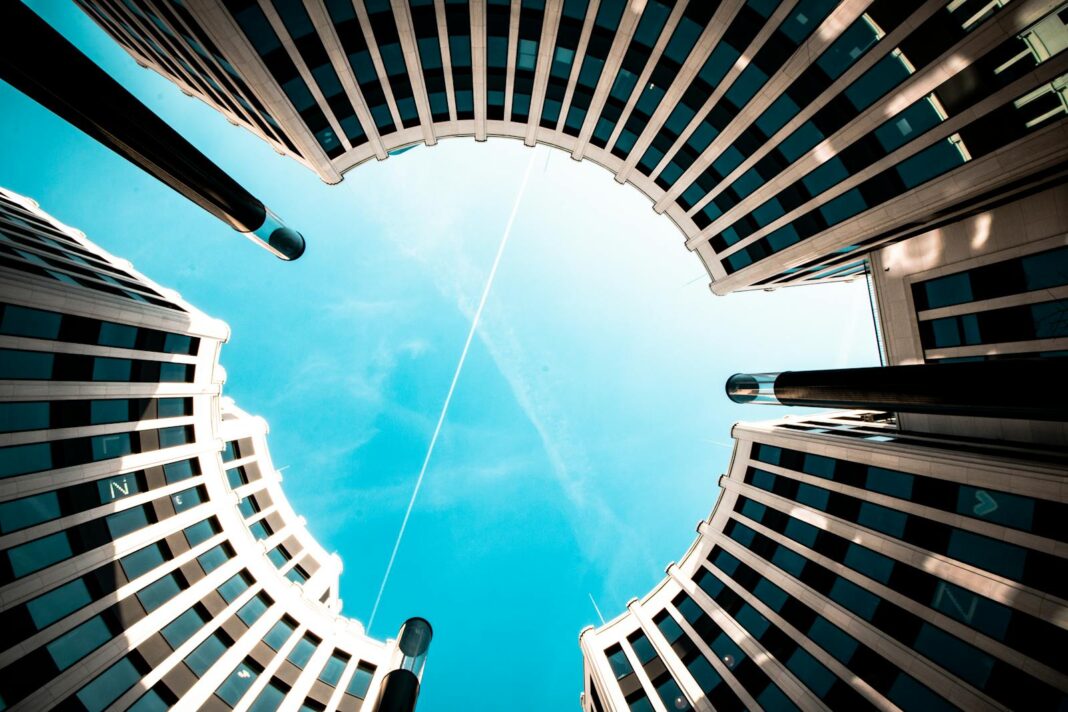 Low angle view of modern circular buildings against a bright blue sky in Berlin.